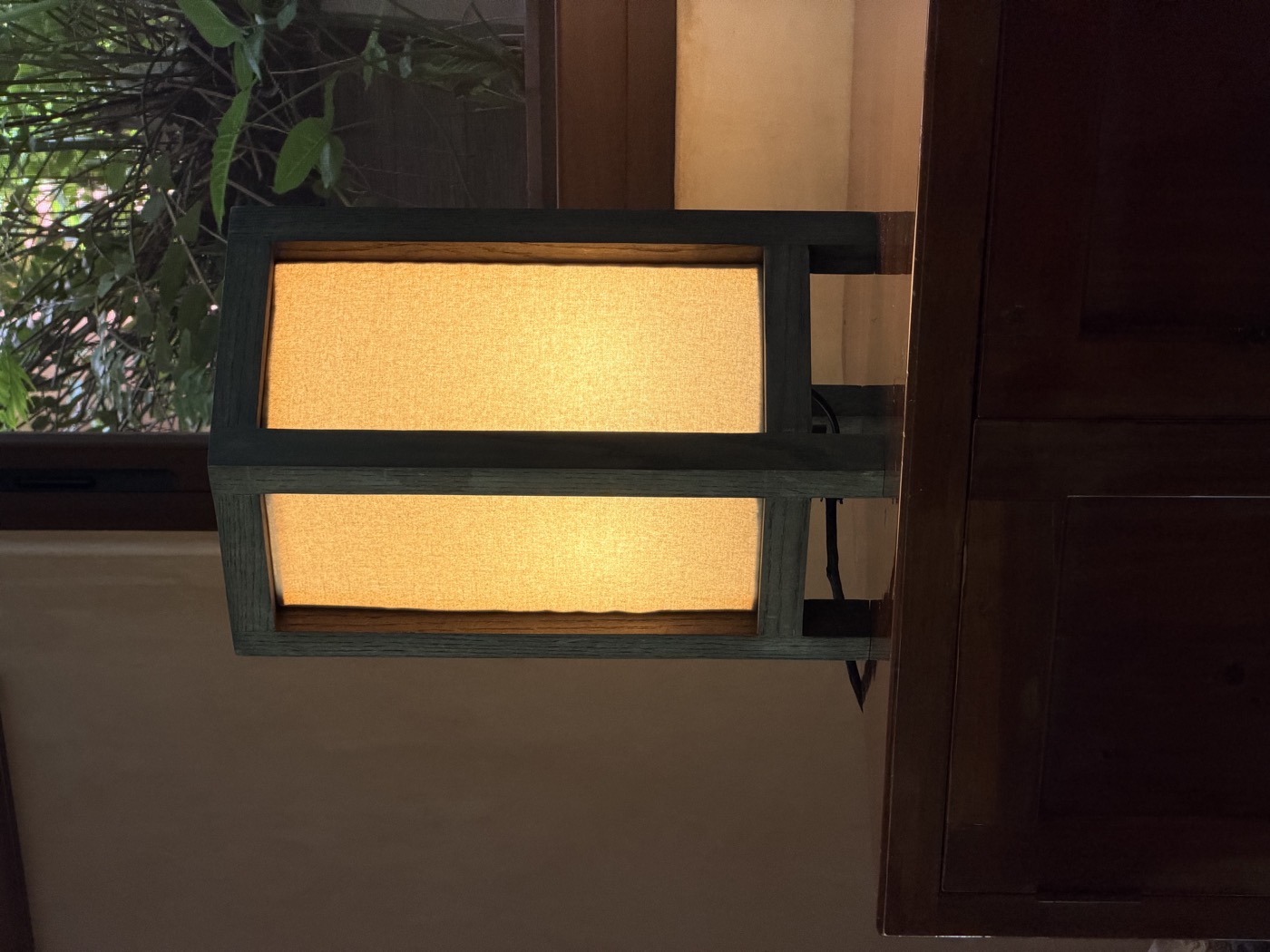Lámpara sobre un mueble de madera junto a la ventana